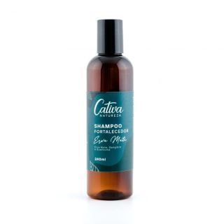 Fundo branco, ao centro o produto embalagem marrom escuro e rótulo verde escuro descrito Cativa Natureza shampoo fortalecedor erva mate, gengibre e Guanxuma, 240mL.