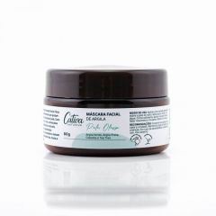 Fundo branco com embalagem marrom escura ao centro da imagem com rótulo branco descrito Cativa Natureza, Máscara facial de argila, pele oleosa, argila verde, argila preta, copaíba e Tea Tree.
