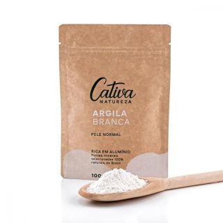 Fundo branco com embalagem de papel marrom ao centro da imagem descrito Cativa Natureza Argila branca, pele normal, rica em alumínio fontes minerais selecionadas 100% naturais do Brasil 100g. Logo a frente da embalagem no canto esquerdo contém uma colher