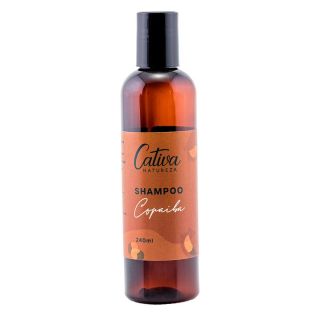 Fundo branco com embalagem marrom escuro ao centro da imagem com rótulo marrom claro descrito Cativa Natureza shampoo Copaíba 240mL.