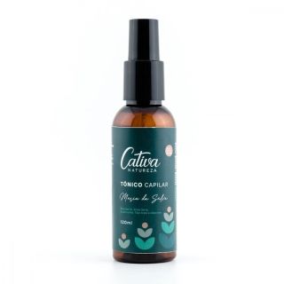 Fundo branco com embalagem marrom escura ao centro da imagem, rótulo verde escuro descrito Cativa Natureza tônico capilar Maria da Selva, Mulateiro, Aloe Vera, Guanxuma, Tea Tree e Alecrim 120mL.