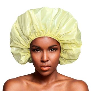 fundo branco e ao centro mulher negra com touca de pvc grande de cor amarela.